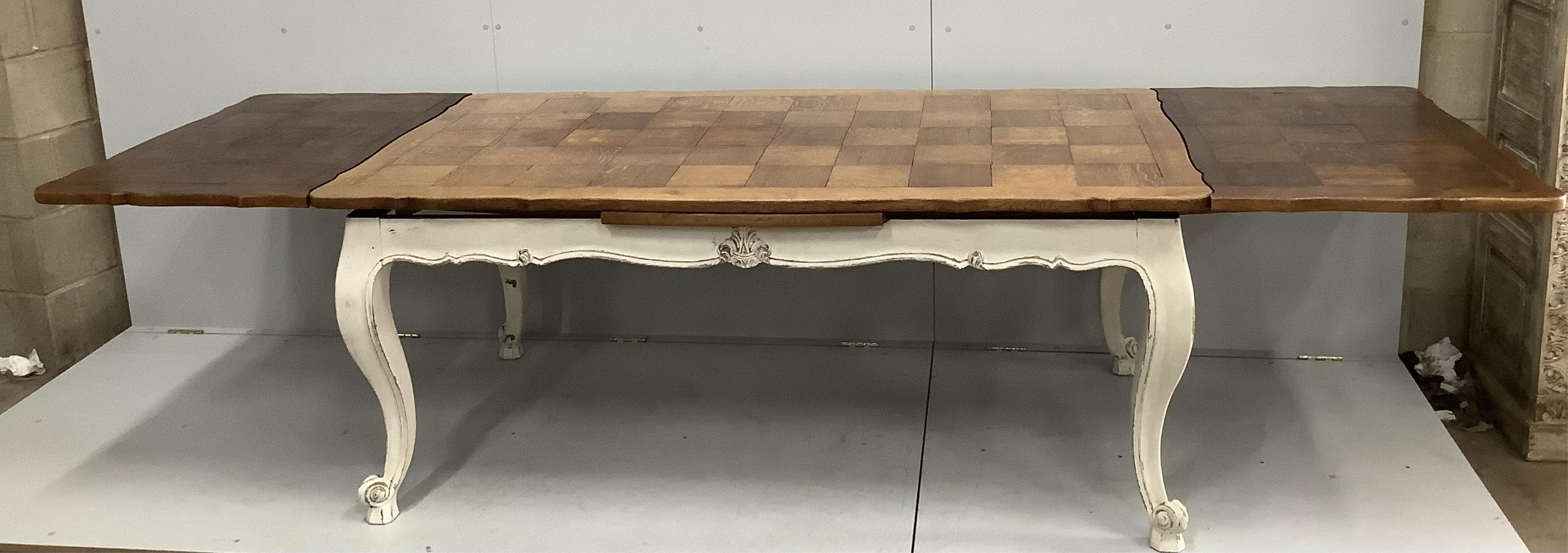 An early 20th century French part painted oak draw leaf extending dining table, width 300cm extended, depth 98cm, height 74cm
